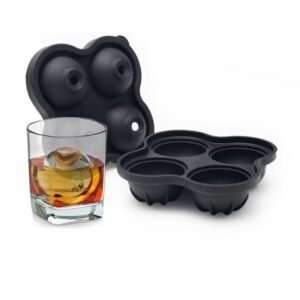 Molde de silicona negro para hielos esféricos junto a un vaso con whisky.